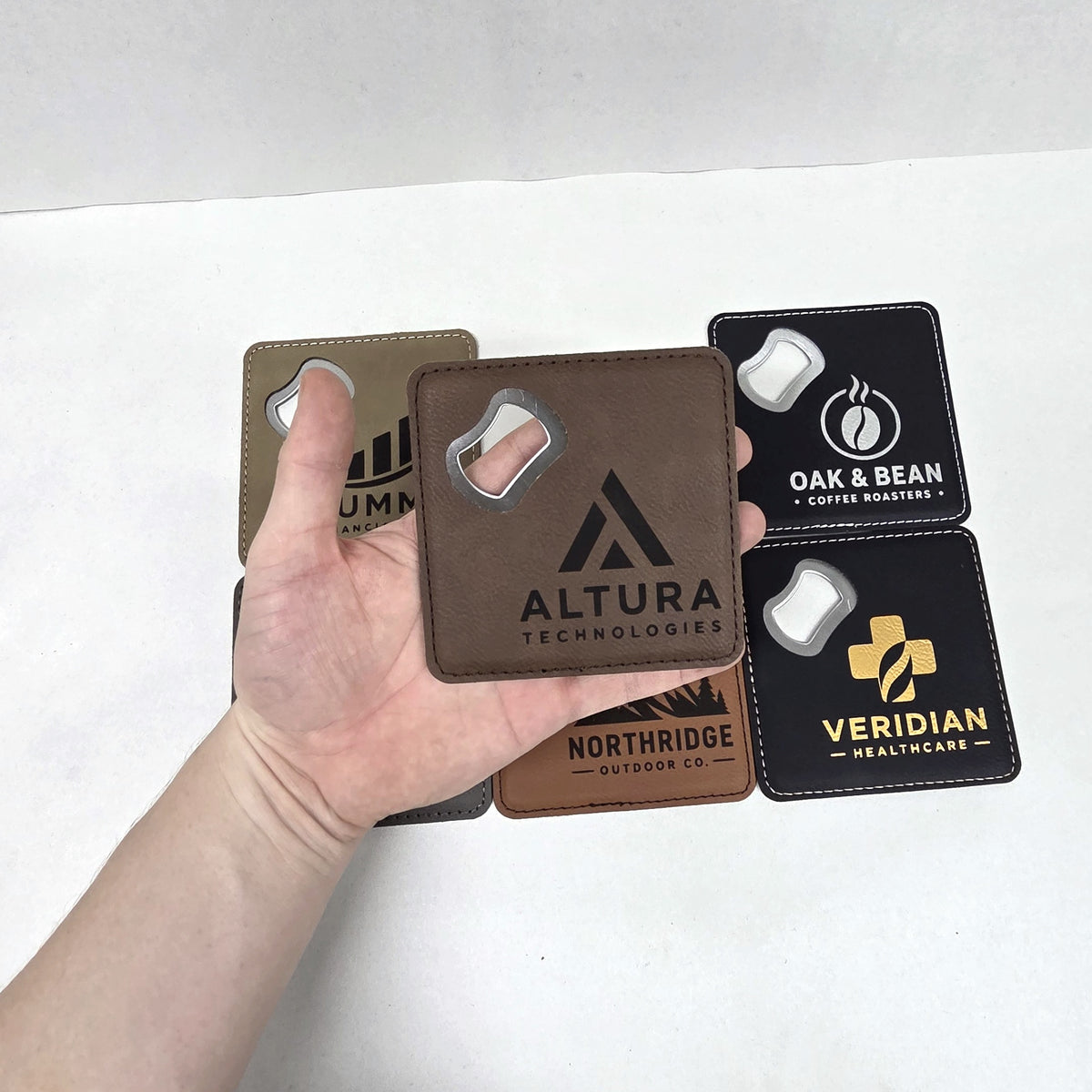 Leatherette coaster bottle opener held in hand to show scale